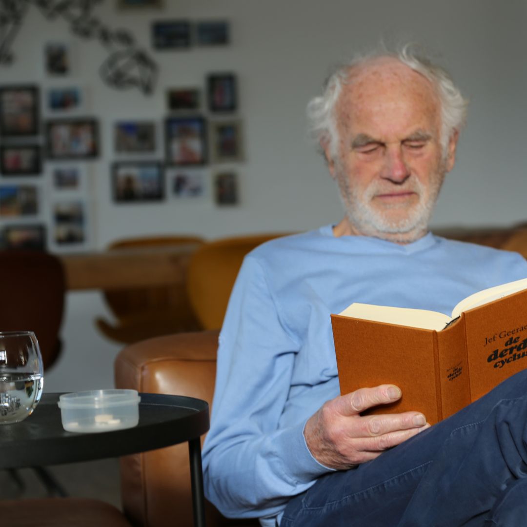 an older adult reading a book at sunset