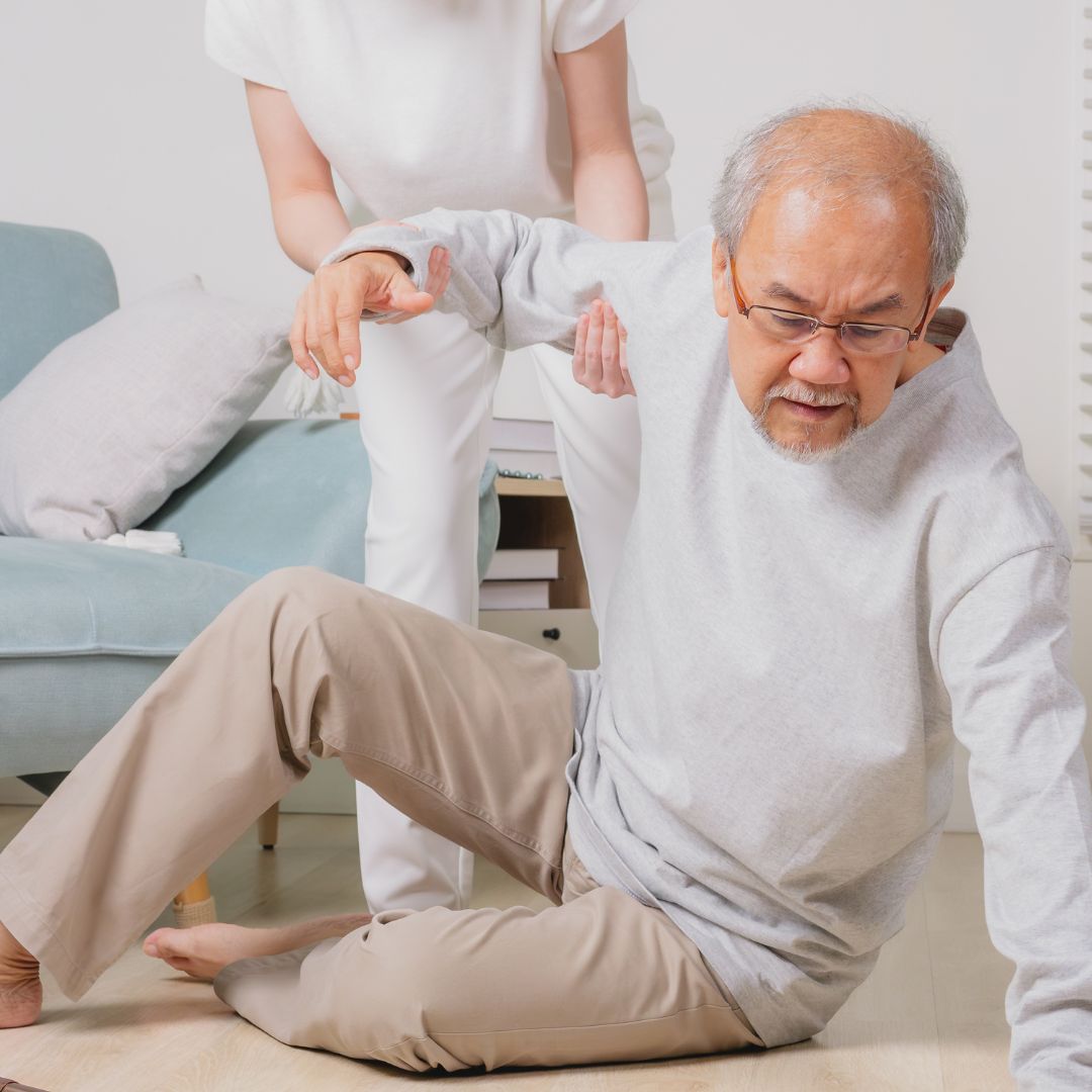 an older adult on the floor being assisted by a person