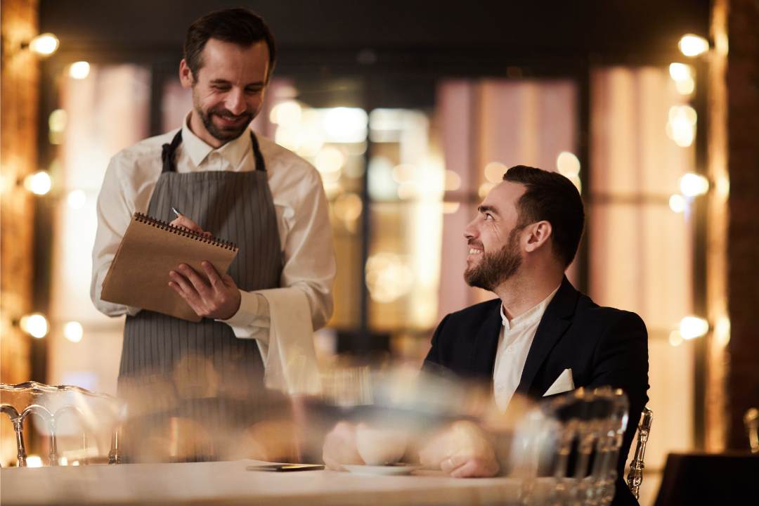 a waiter in a restaurant next to a customer